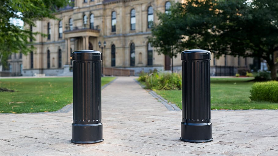 Crash-rated decorative bollards installed along a pedestrian path in front of a historic civic building.