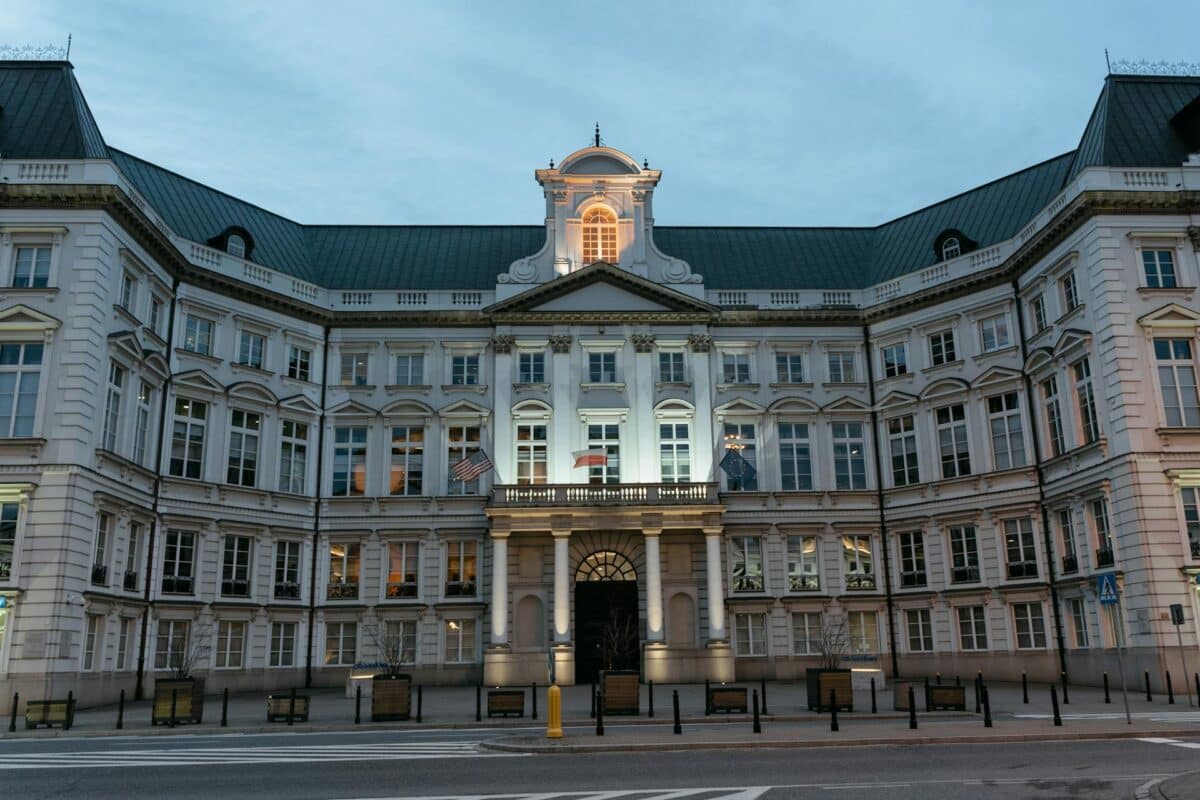 Historic government-style building at dusk with discreet bollards lining the entrance to separate pedestrians from the roadway.