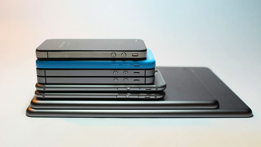 Pila de teléfonos inteligentes y tabletas organizados por tamaño, que simbolizan el cambio tecnológico.