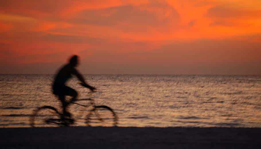 A cyclist in silhouette at sunset