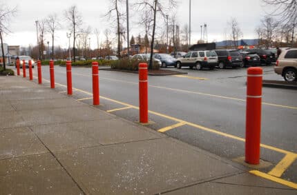 Line of red R-7109 plastic bollard covers on street