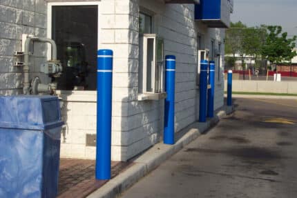Blue R-7111 plastic bollard covers next to building wall