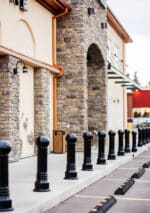 Row of R-7592 decorative bollards in front of brick building